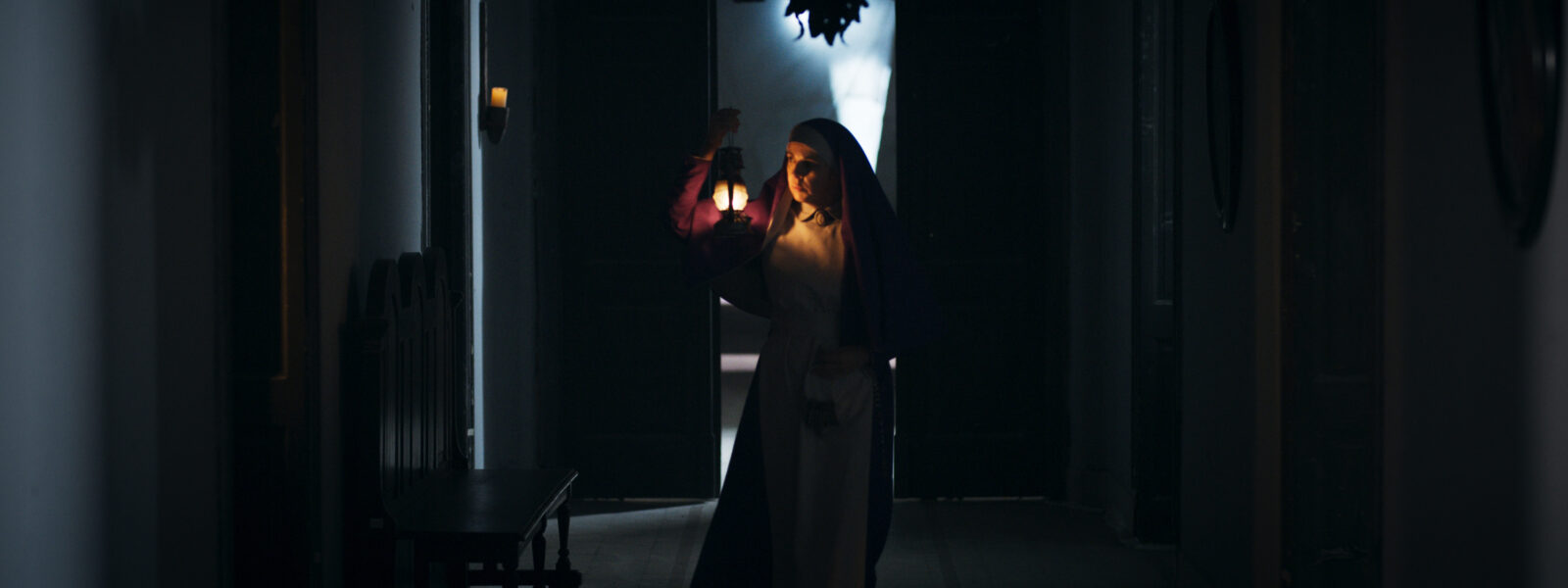 A nun holds a lantern.
