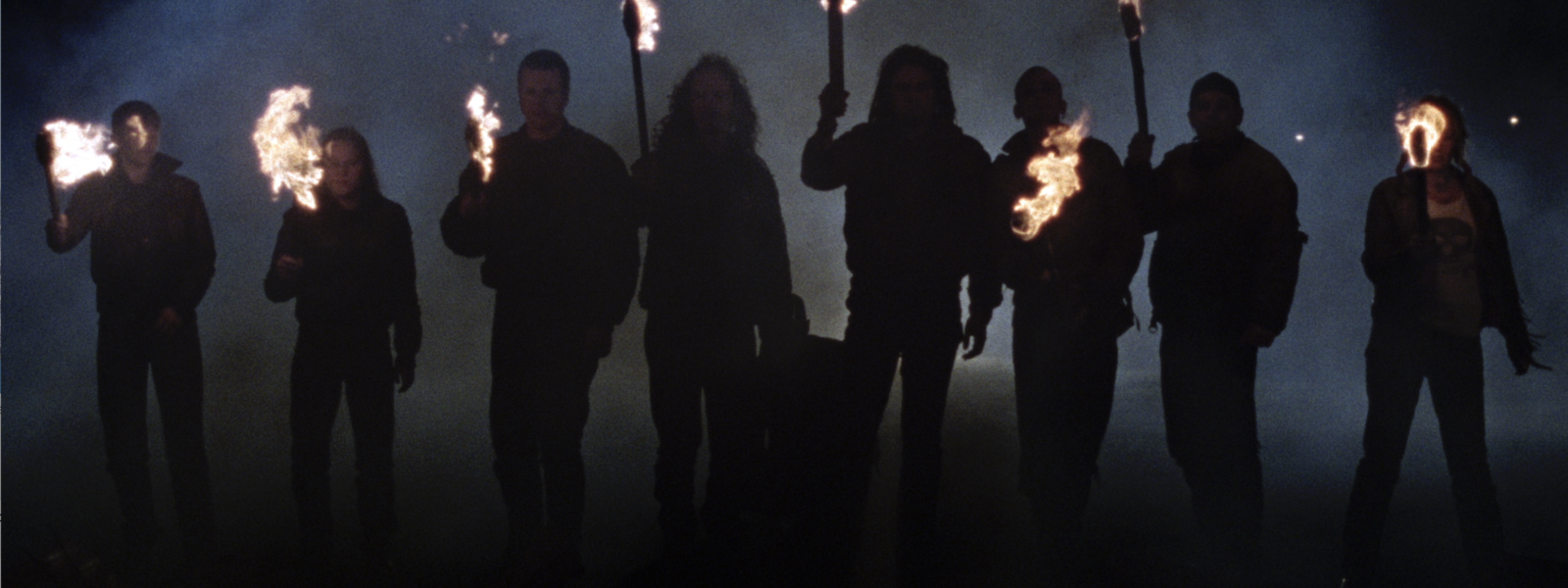 A group of people hold flaming torches