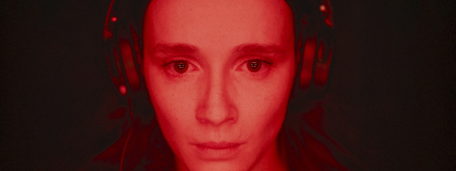 Woman with headphones in red light