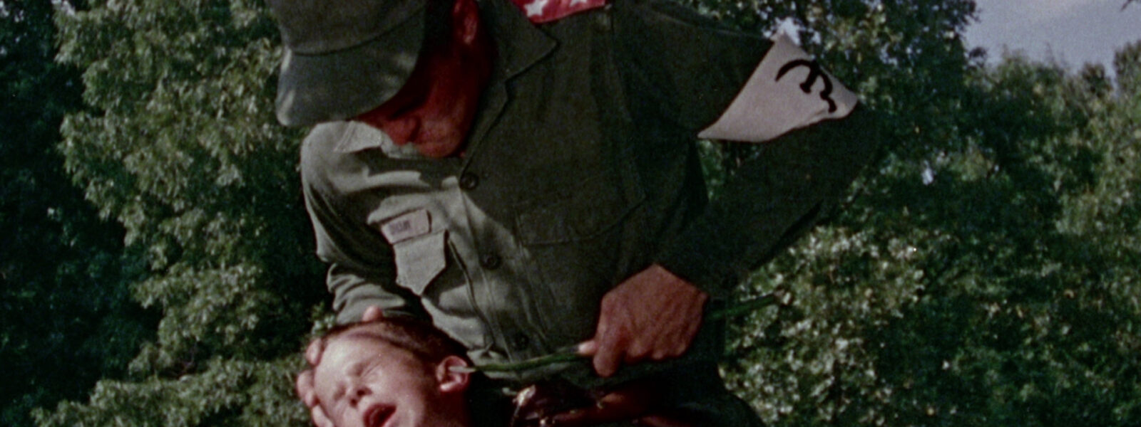 A soldier is stabbing a small boy