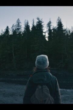 A girl watches a tree covered island