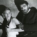 A burly man holding a girl